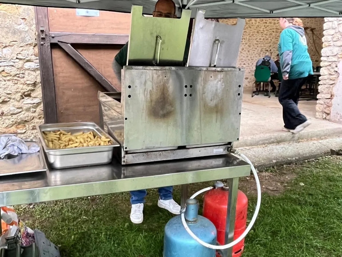 Friteuse à gaz professionnelle installée lors d'un événement extérieur avec bouteilles gaz